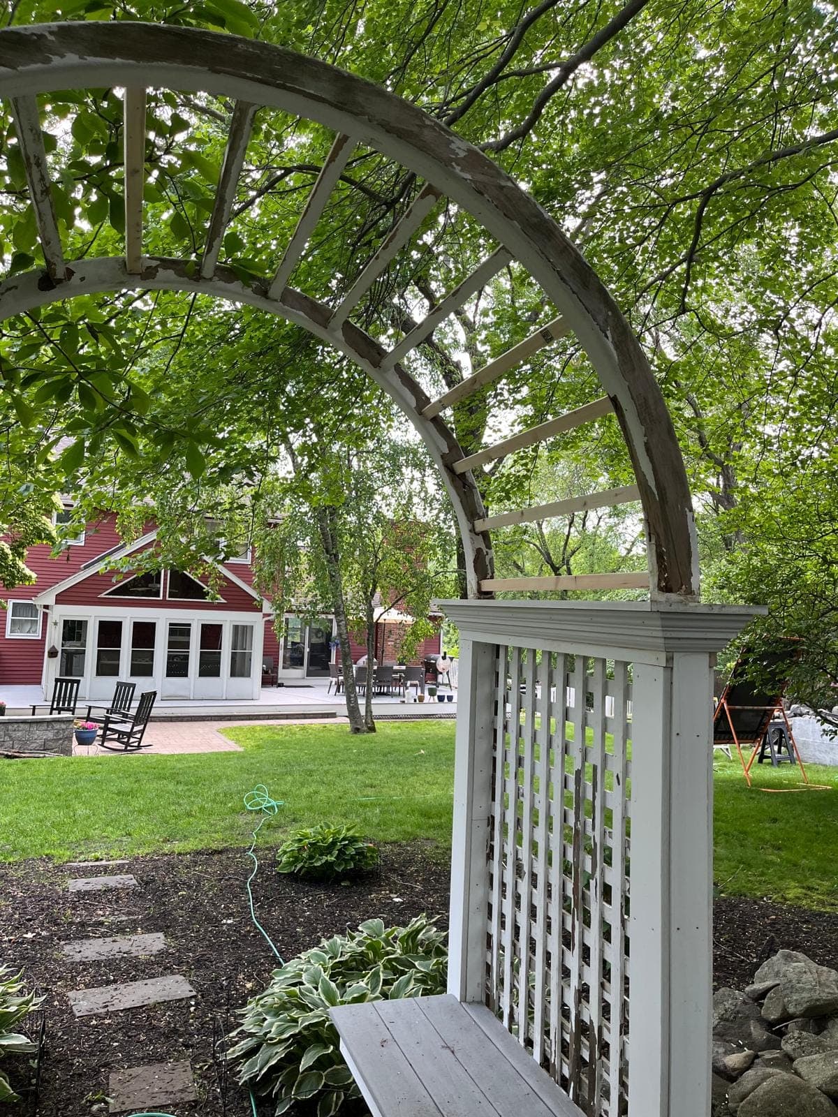 Close view of a garden arbour's rebuilt arch and new lattice post