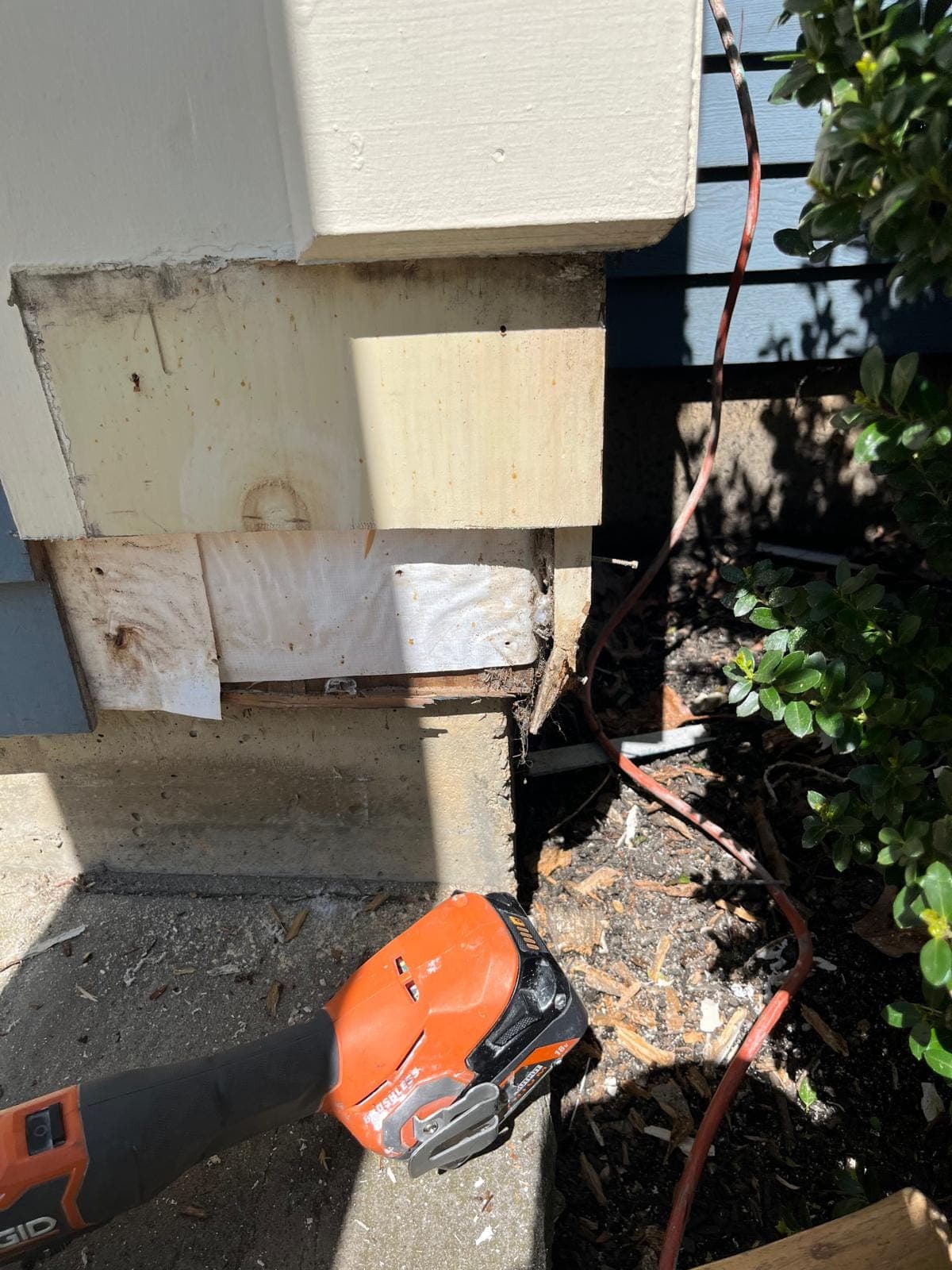 Close view of new primed trim boards meeting at a corner above a foundation