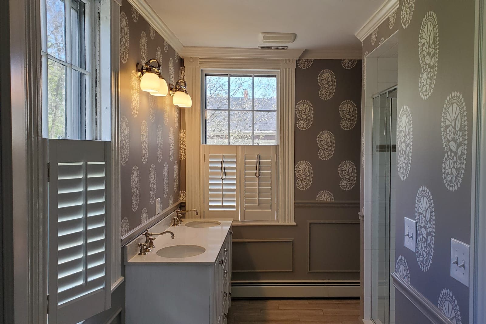 Powder room with grey medallion-print wallpaper, plantation shutters and a white vanity